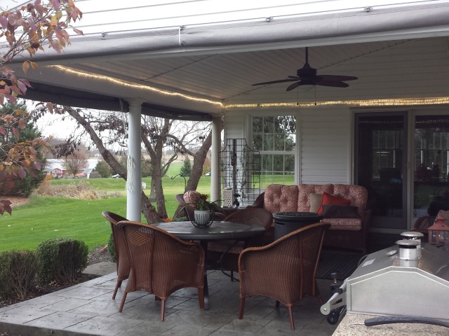 Gray Sunbrella fabric porch curtains with clear vinyl panels