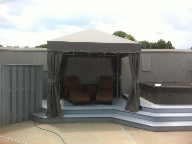 Freestanding poolside cabana with corner curtains