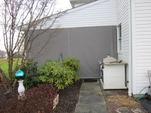 Gray Sunbrella fabric porch curtains with clear vinyl panels