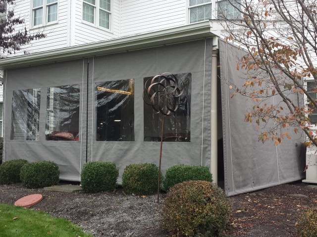 Clear vinyl sunbrella fabric drop curtains on a porch