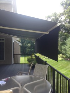 Side view of a retractable awning with a drop down screen