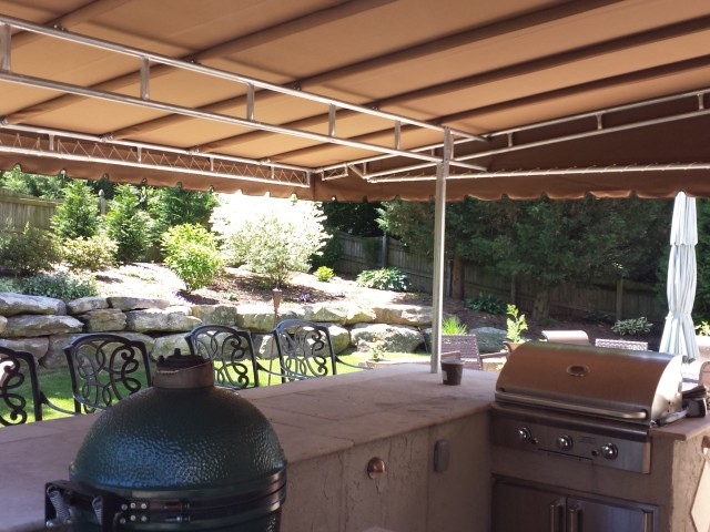 Stationary canopy installed over an outdoor kitchen