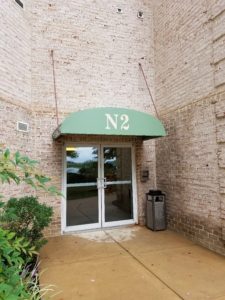 Custom arched doorhood awning at retirement home entrance