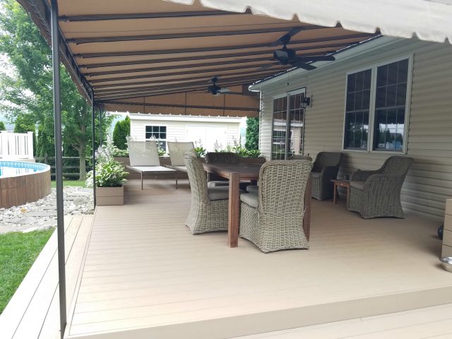 Beige Sunbrella deck awning with ceiling fans