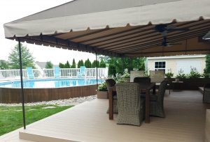 Beige Sunbrella deck awning with ceiling fans